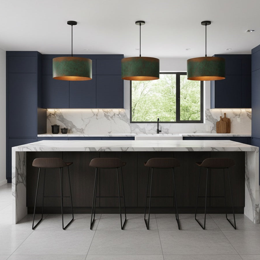 Modern kitchen with dark blue cabinets, white marble island, and green pendant lights.