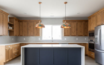 Modern kitchen with wooden cabinets, a blue island, and stainless steel appliances.