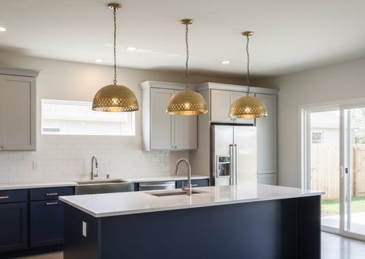 Modern kitchen with white countertops, blue cabinets, and gold pendant lights.
