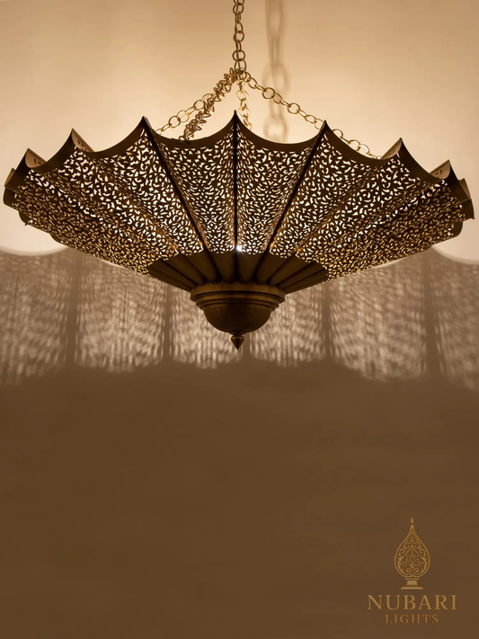 Decorative chandelier with intricate design casting shadows on a wall, Nubari Lights logo visible.