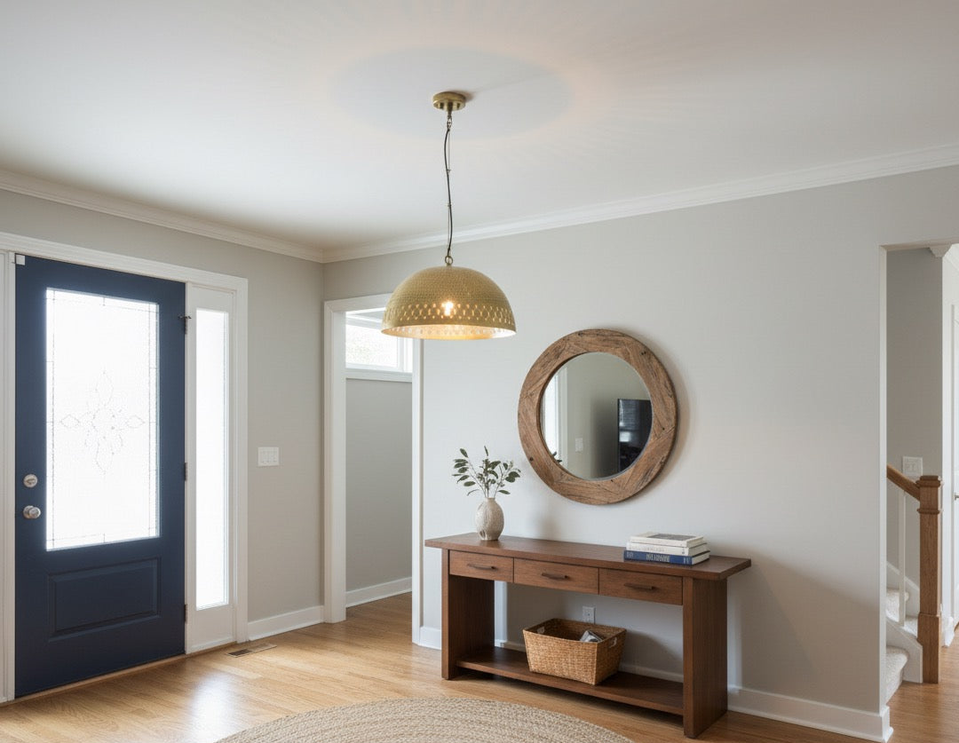 Foyer with a wooden console table, round mirror, and blue door.